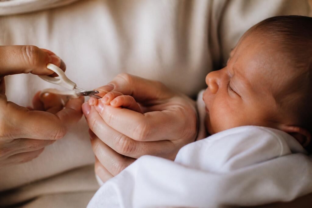 Parent gently trimming a newborn's fingernails with baby scissors